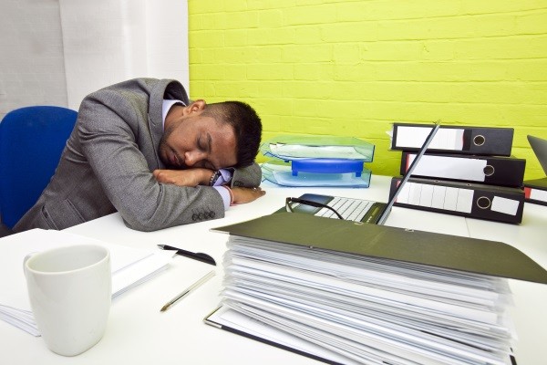 Man asleep by computer frustrated by need for natural sounding writing