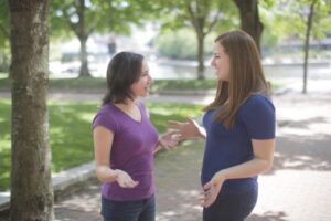 2 women in park listening to each other