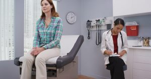 Quiet scene of mid aged patient and doctor sitting in medical room