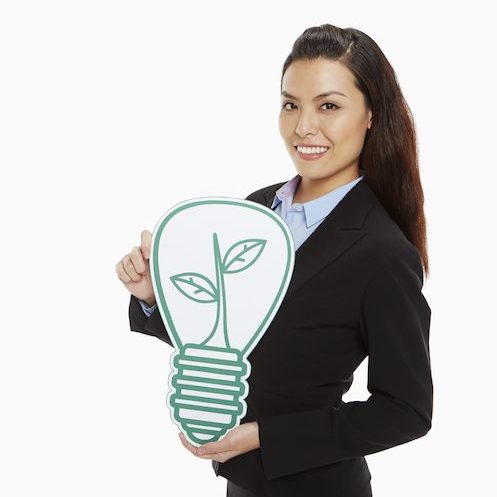 Cheerful businesswoman holding up a cut out light bulb