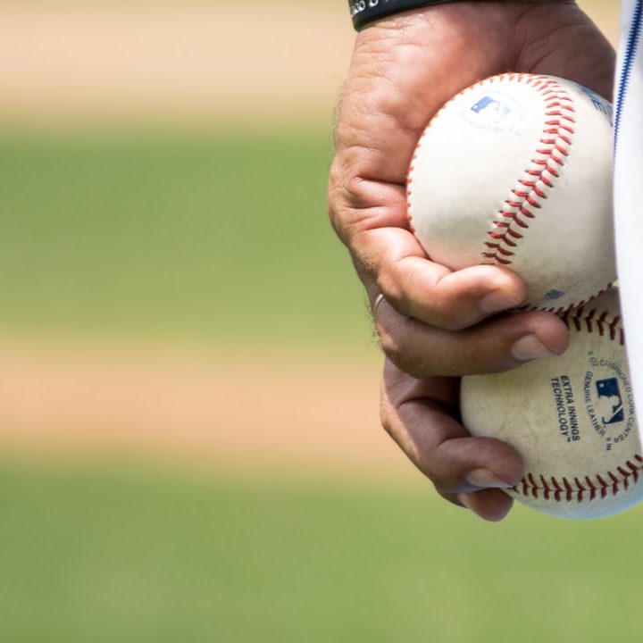 pitcher holding baseballs